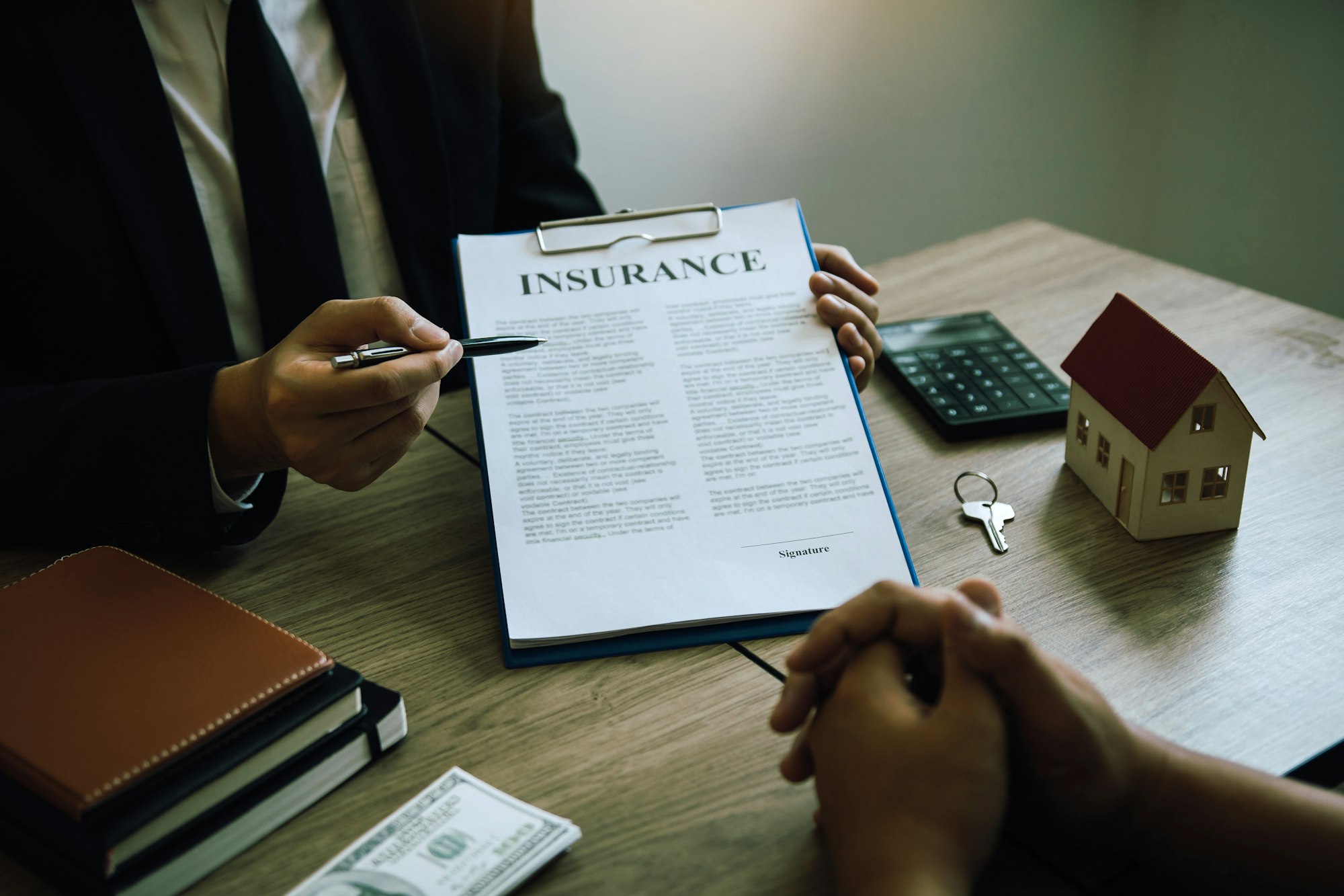 Agents are using pens pointing to insurance contracts and are being explained to customers